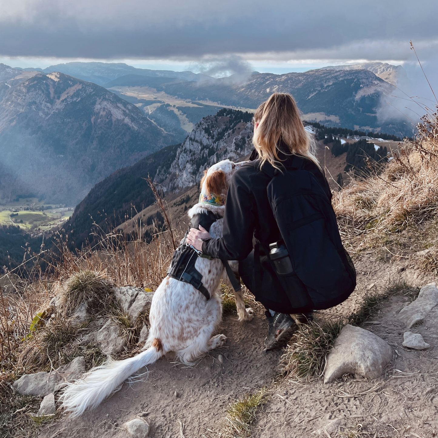 Chien équipée du harnais Trekka noir OrkaDog avec femme, moment de complicité pendant une randonnée